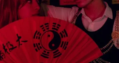 Ruang tamu vintage yang nyaman dengan sofa Chesterfield hijau beludru, meja kopi kayu antik, dan pencahayaan hangat dari lampu lantai kuningan, menciptakan suasana nostalgia dan elegan.