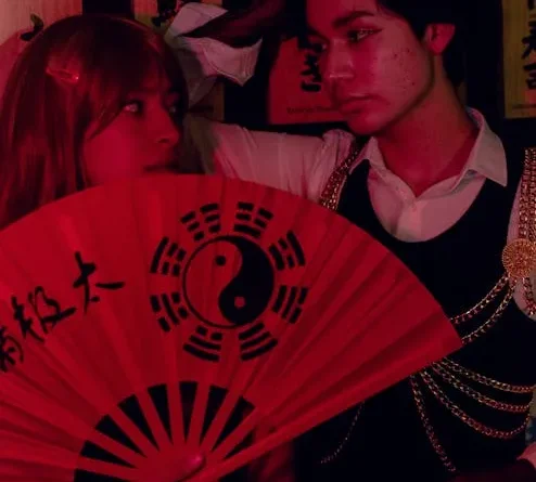 Ruang tamu vintage yang nyaman dengan sofa Chesterfield hijau beludru, meja kopi kayu antik, dan pencahayaan hangat dari lampu lantai kuningan, menciptakan suasana nostalgia dan elegan.