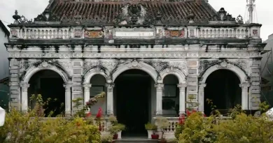 Sekelompok orang beragam usia bekerja sama di kebun kota yang hijau, menyiratkan komunitas dan gaya hidup berkelanjutan.