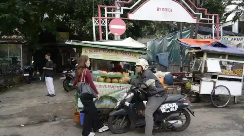 Seorang anak muda yang fokus memulai bisnis online dengan laptopnya di pagi hari, menggambarkan semangat wirausaha tanpa modal besar.