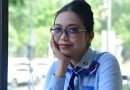 Seorang wanita profesional muda berbicara dengan percaya diri di atas panggung