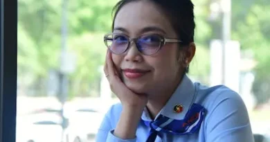 Seorang wanita profesional muda berbicara dengan percaya diri di atas panggung