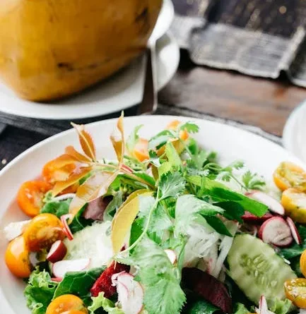 Sepiring penuh masakan sehat diet yang lezat dengan ayam panggang, sayuran panggang berwarna-warni, dan quinoa.