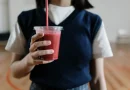 Smoothie sehat berwarna-warni dalam gelas dengan buah segar di sekitarnya, cocok untuk sarapan atau diet.