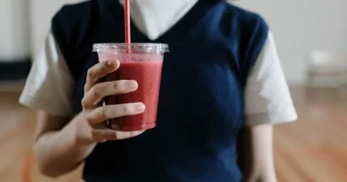 Smoothie sehat berwarna-warni dalam gelas dengan buah segar di sekitarnya, cocok untuk sarapan atau diet.